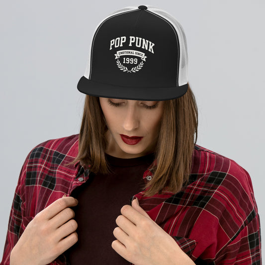 Person wearing a black and white cap with 'Pop Punk Emotional Since 1999' text, red plaid shirt, and dark shirt.