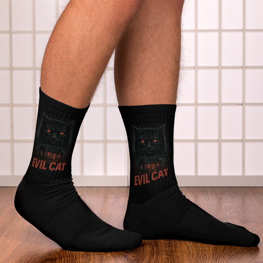 Black socks with a cat design and 'Evil Cat' text worn by a person on a tiled floor.