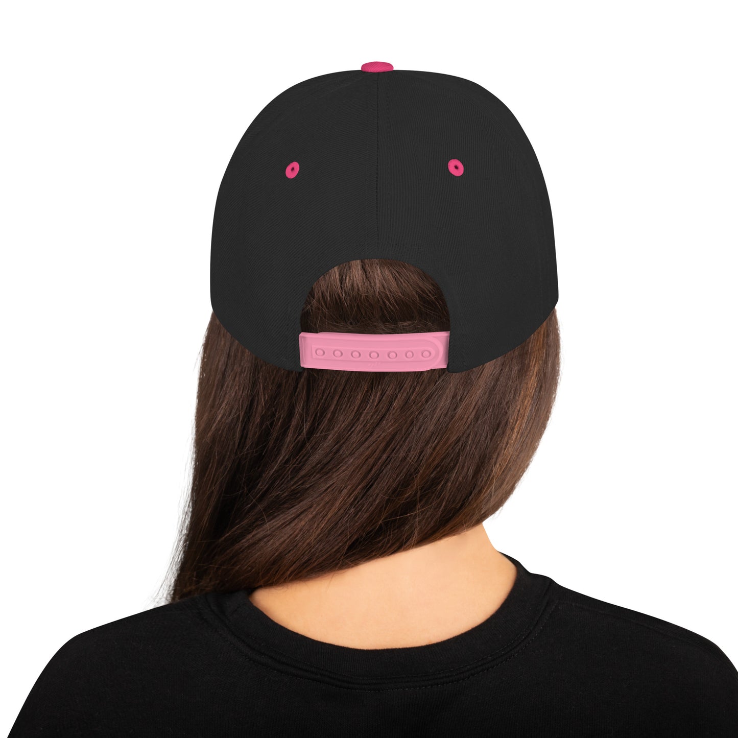 Black cap with pink accents worn by a person on a white background