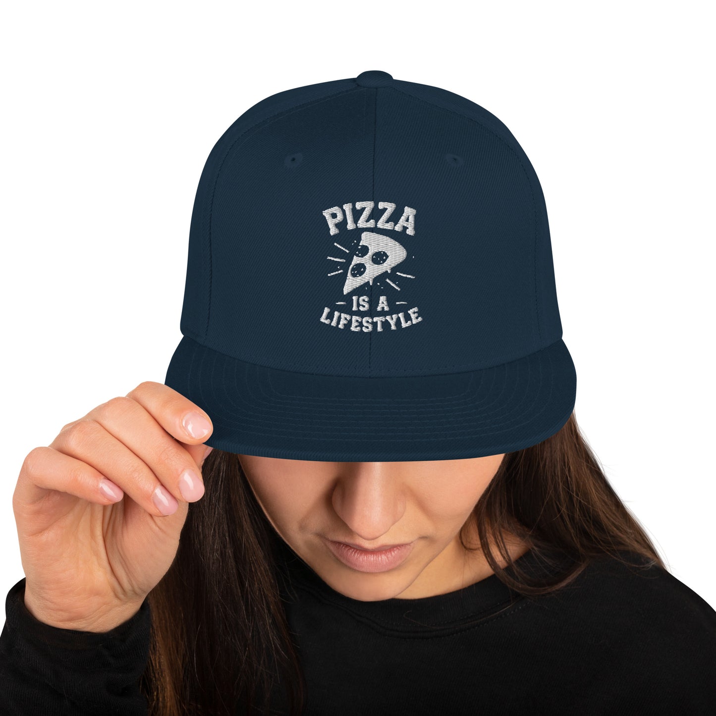 Navy blue cap with 'Pizza is a Lifestyle' text held by a person on a white background