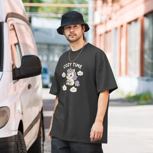 Man wearing a dark grey t-shirt with a unicorn graphic and 'Cozy Time' text, standing next to a van.