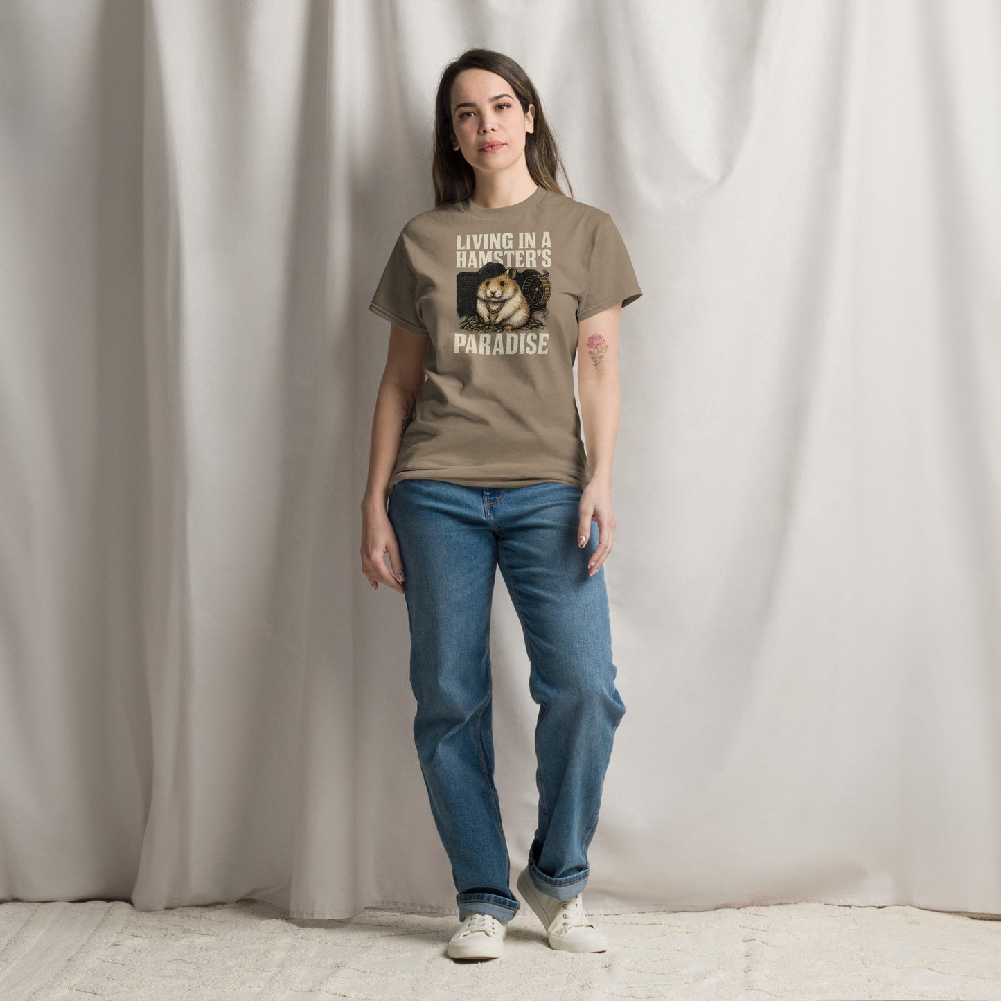 Person wearing a brown t-shirt with a graphic and text, standing against a plain background