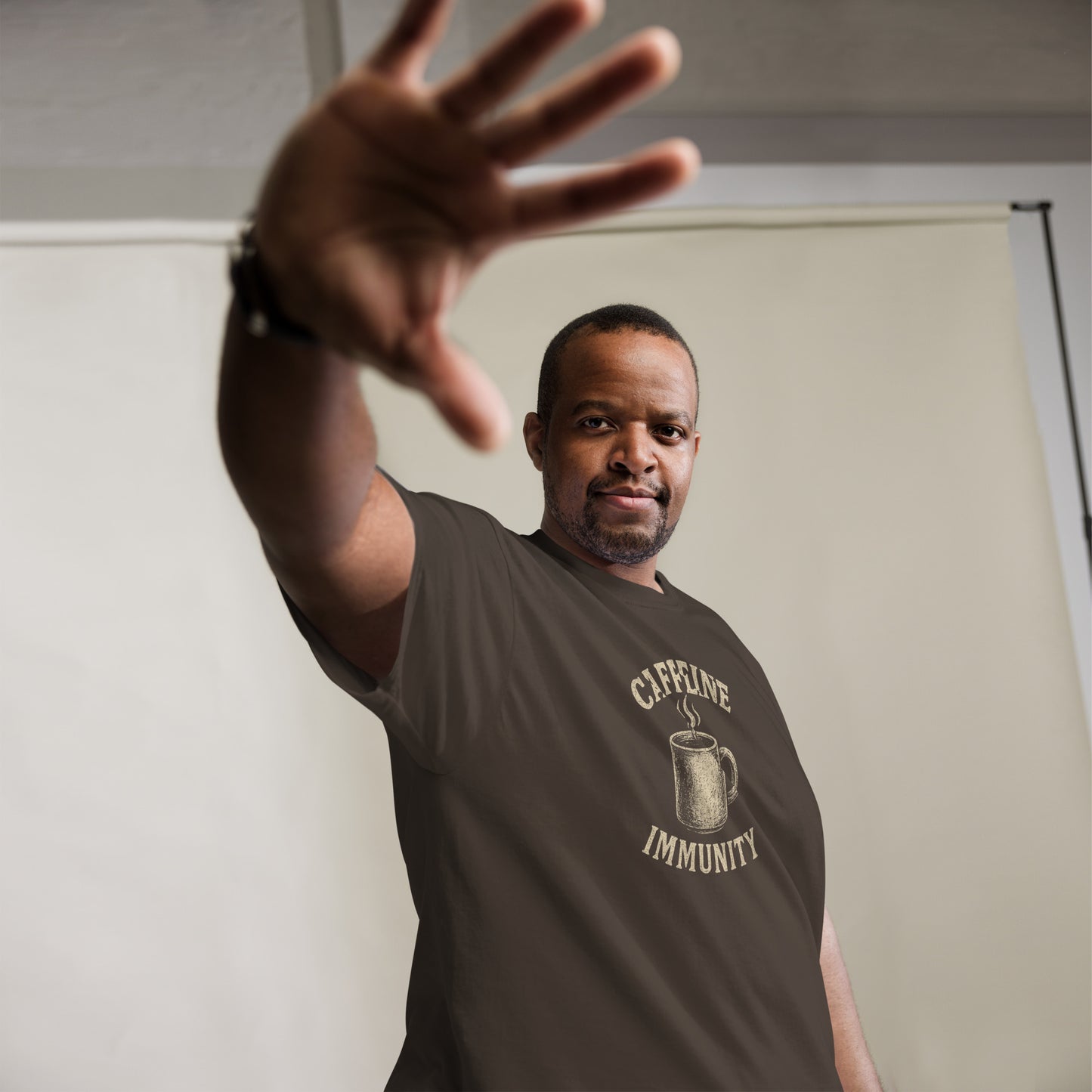 Man wearing a t-shirt with 'Coffee Immunity' graphic, reaching out with one hand.