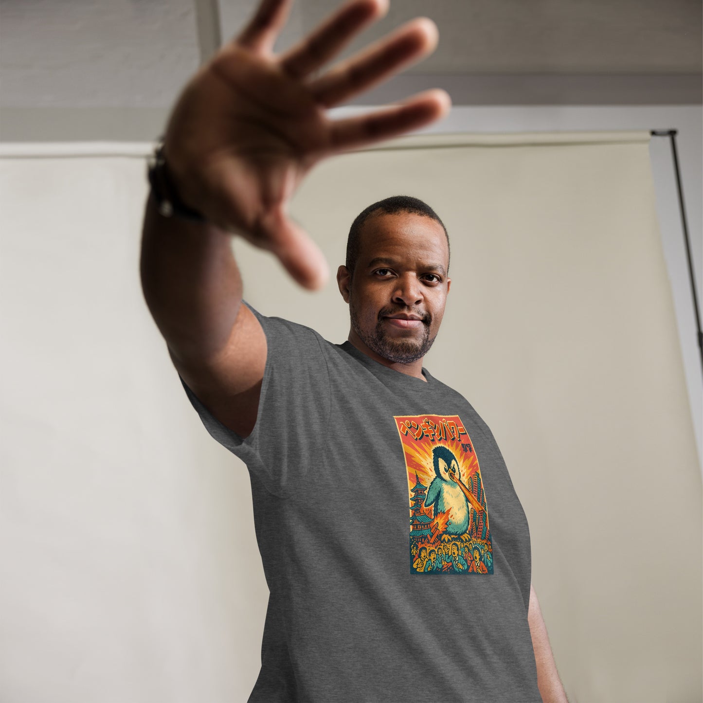 Man wearing a gray t-shirt with a colorful graphic design, standing against a plain background.