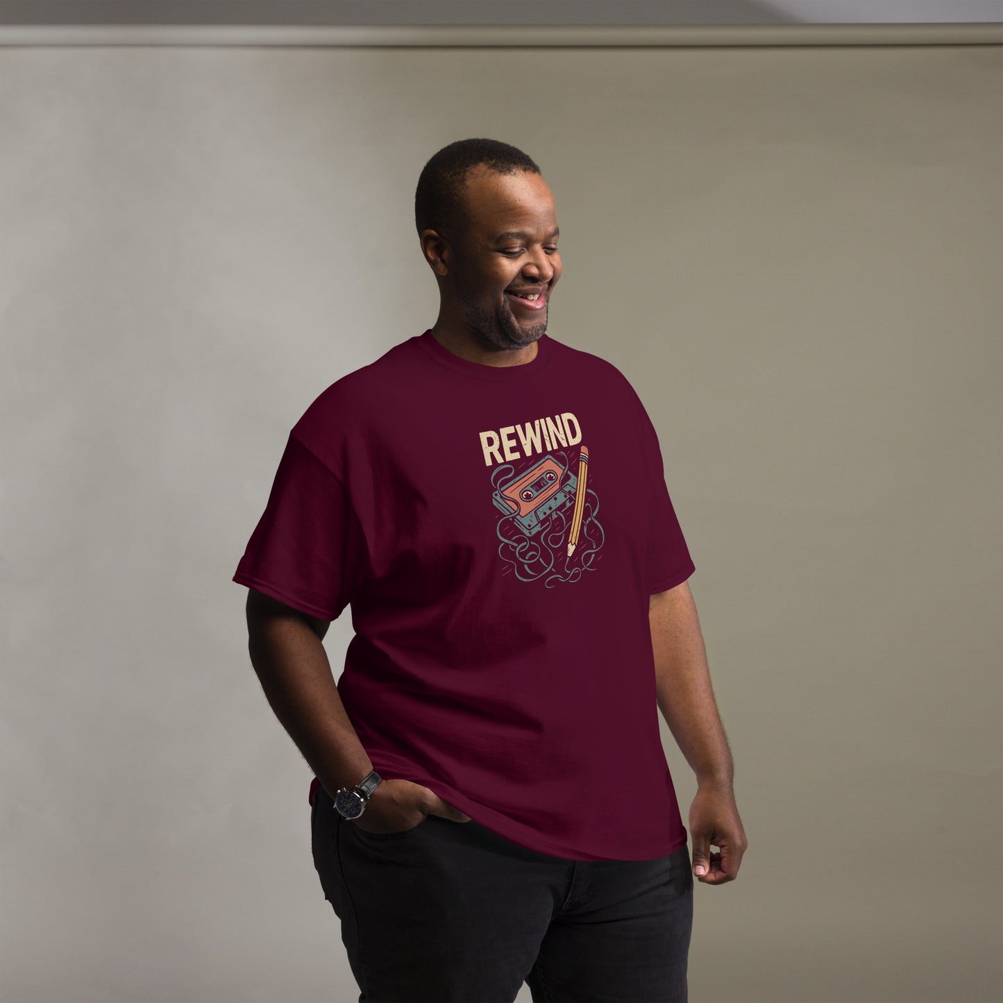 Man wearing a maroon t-shirt with 'REWIND' graphic design on a plain background