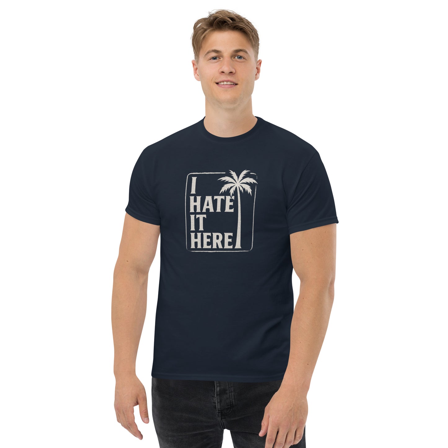 Man wearing a navy blue t-shirt with 'I HATE IT HERE' text and palm tree design on a white background