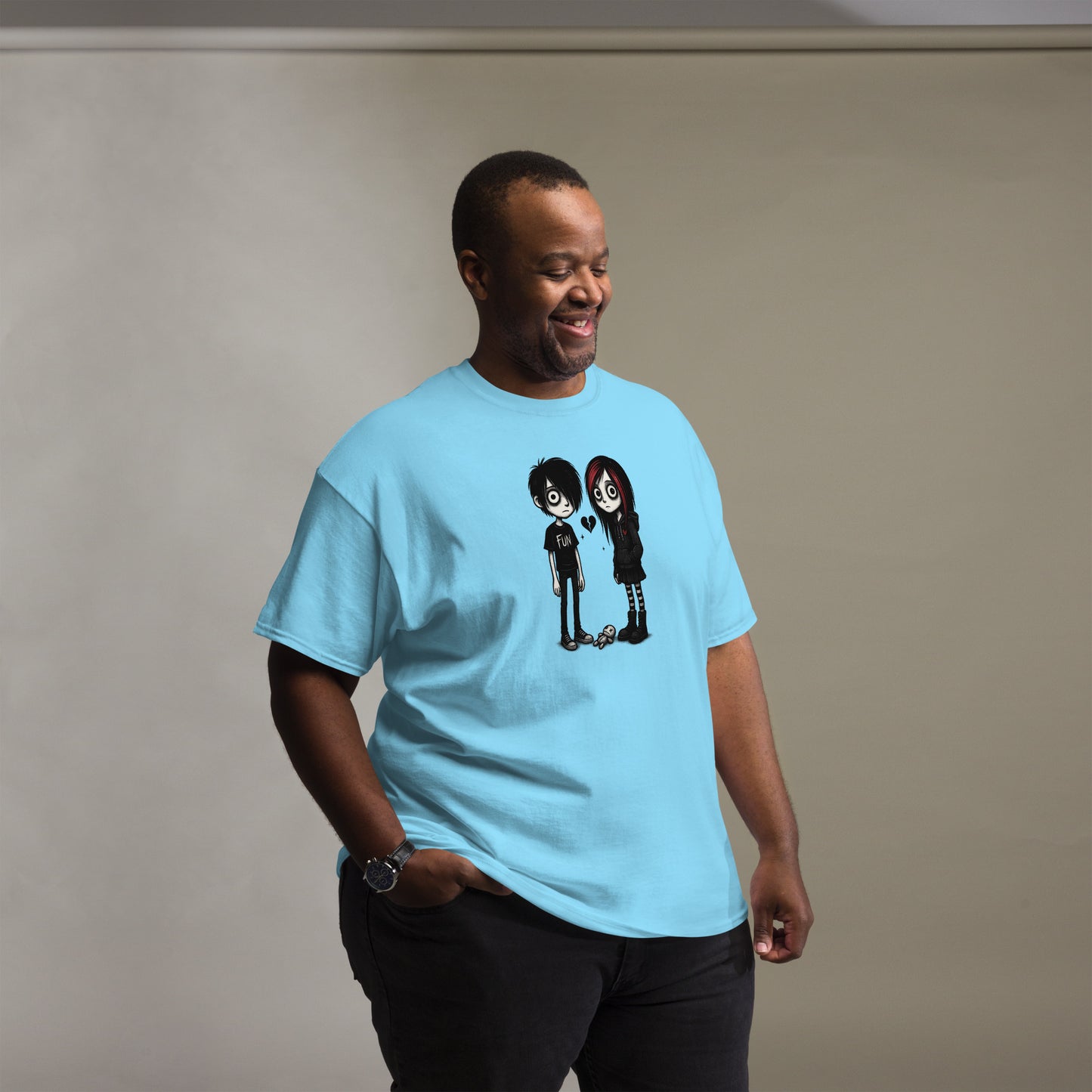 Man wearing a light blue t-shirt with a graphic design on a plain background