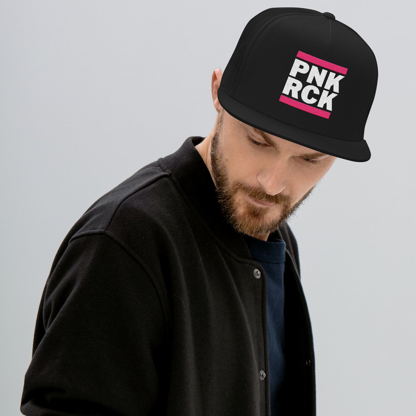 Man wearing a black cap with 'PNK RCK' text on a gray background