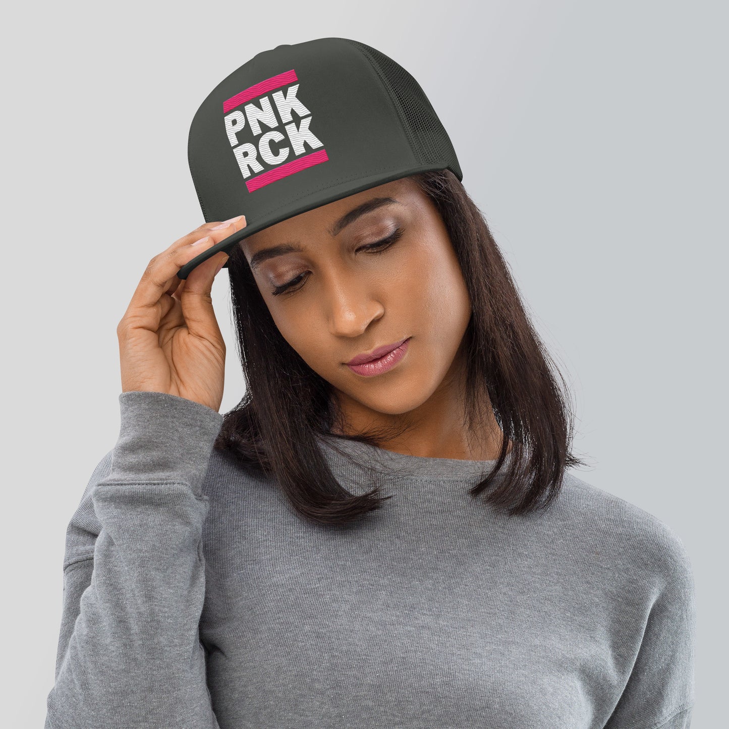 Woman wearing a black cap with 'PNK ROCK' text on a gray background