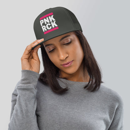 Woman wearing a black cap with 'PNK ROCK' text on a gray background