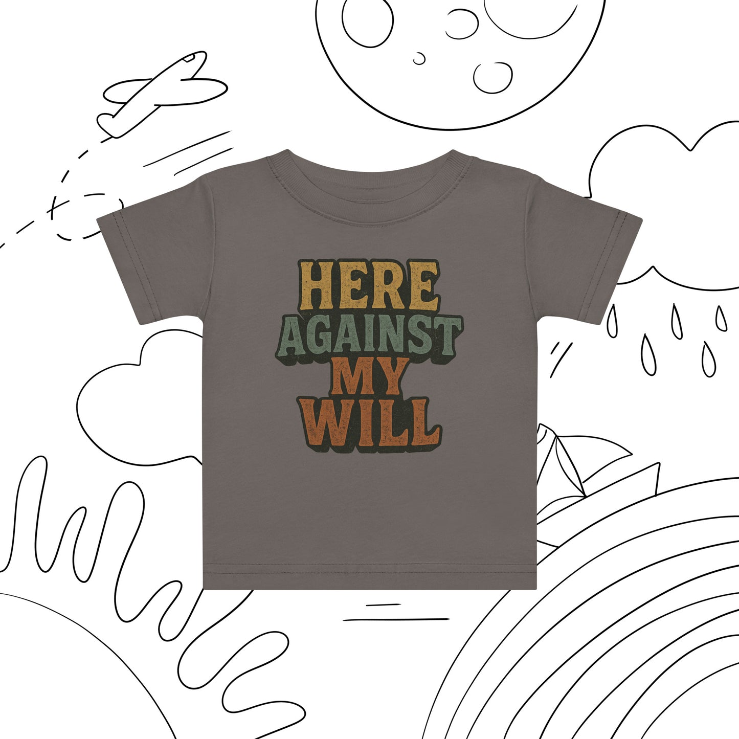 Children's t-shirt with 'HERE AGAINST MY WILL' text on a white background with black line art.