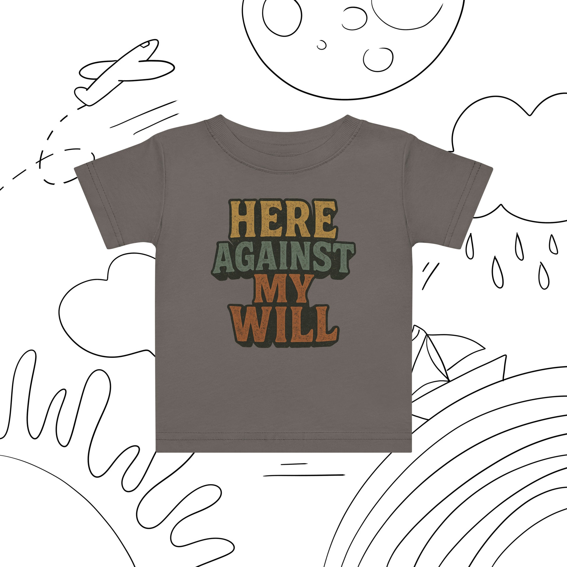 Children's t-shirt with 'HERE AGAINST MY WILL' text on a white background with black line art.