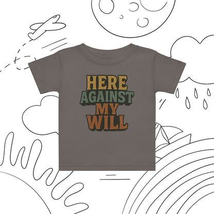 Children's t-shirt with 'HERE AGAINST MY WILL' text on a white background with black line art.