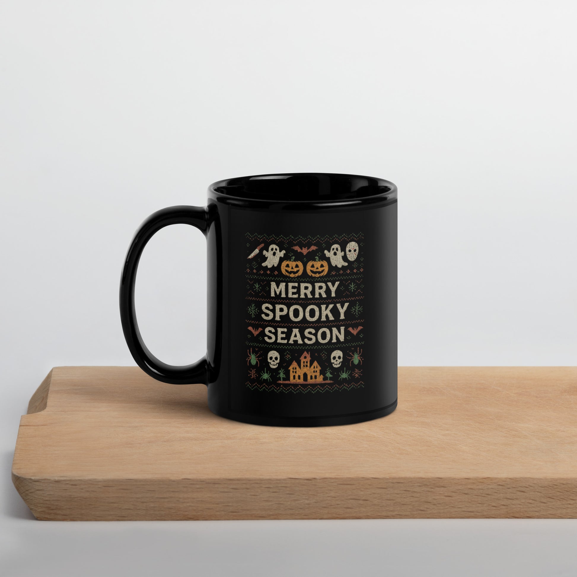 Black mug with Halloween-themed design on a wooden surface