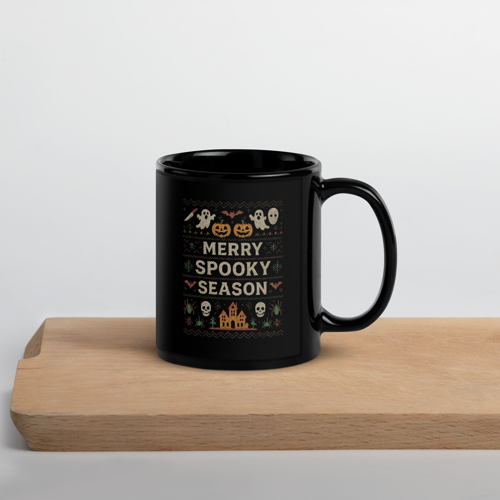 Black mug with Halloween-themed design on a wooden surface