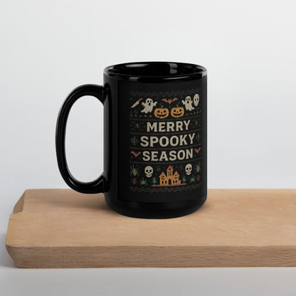 Black mug with Halloween-themed design and 'Merry Spooky Season' text on a wooden surface.