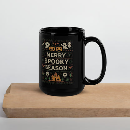Black mug with Halloween-themed design and 'Merry Spooky Season' text on a wooden surface.
