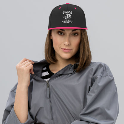 Woman wearing a black cap with 'Pizza is a Lifestyle' text and a gray raincoat on a gray background