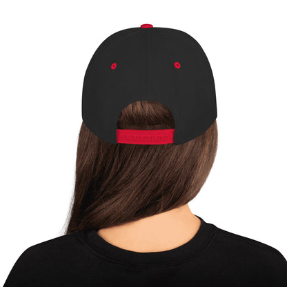 Person wearing a black cap with red accents on a white background