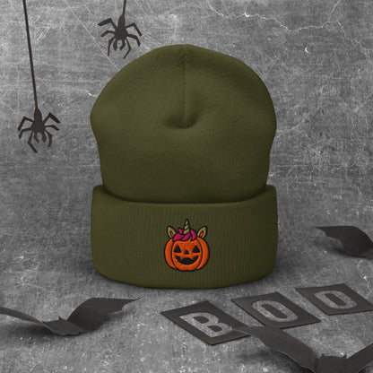 Green beanie with a Halloween pumpkin design on a textured gray background with spider webs and 'BOO' letters.