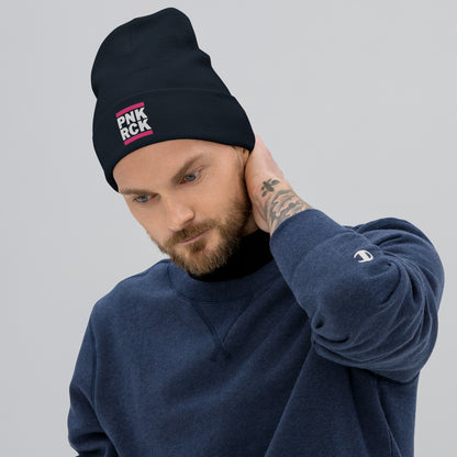 Man wearing a black beanie with 'PNK ROCK' text and a blue sweatshirt on a gray background