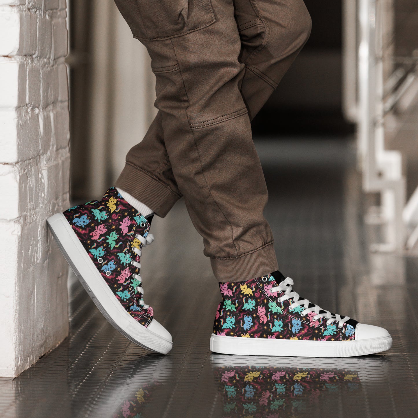 Person wearing high-top sneakers with colorful patterns and brown pants against a neutral background.