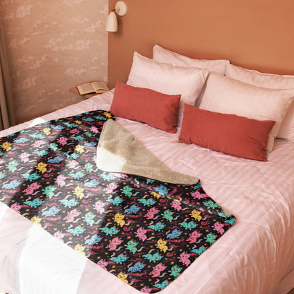Bed with colorful blanket featuring cartoon characters, red pillows, and a beige towel.