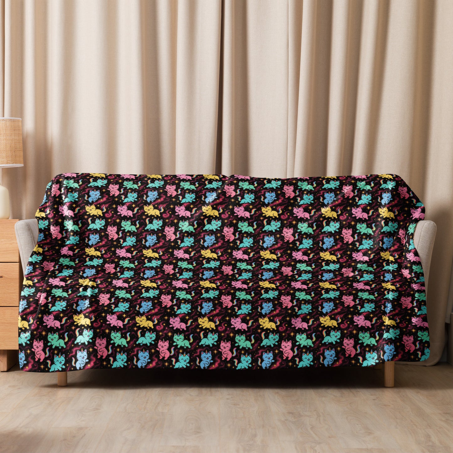 Colorful cat patterned blanket draped over a sofa with beige curtains in the background