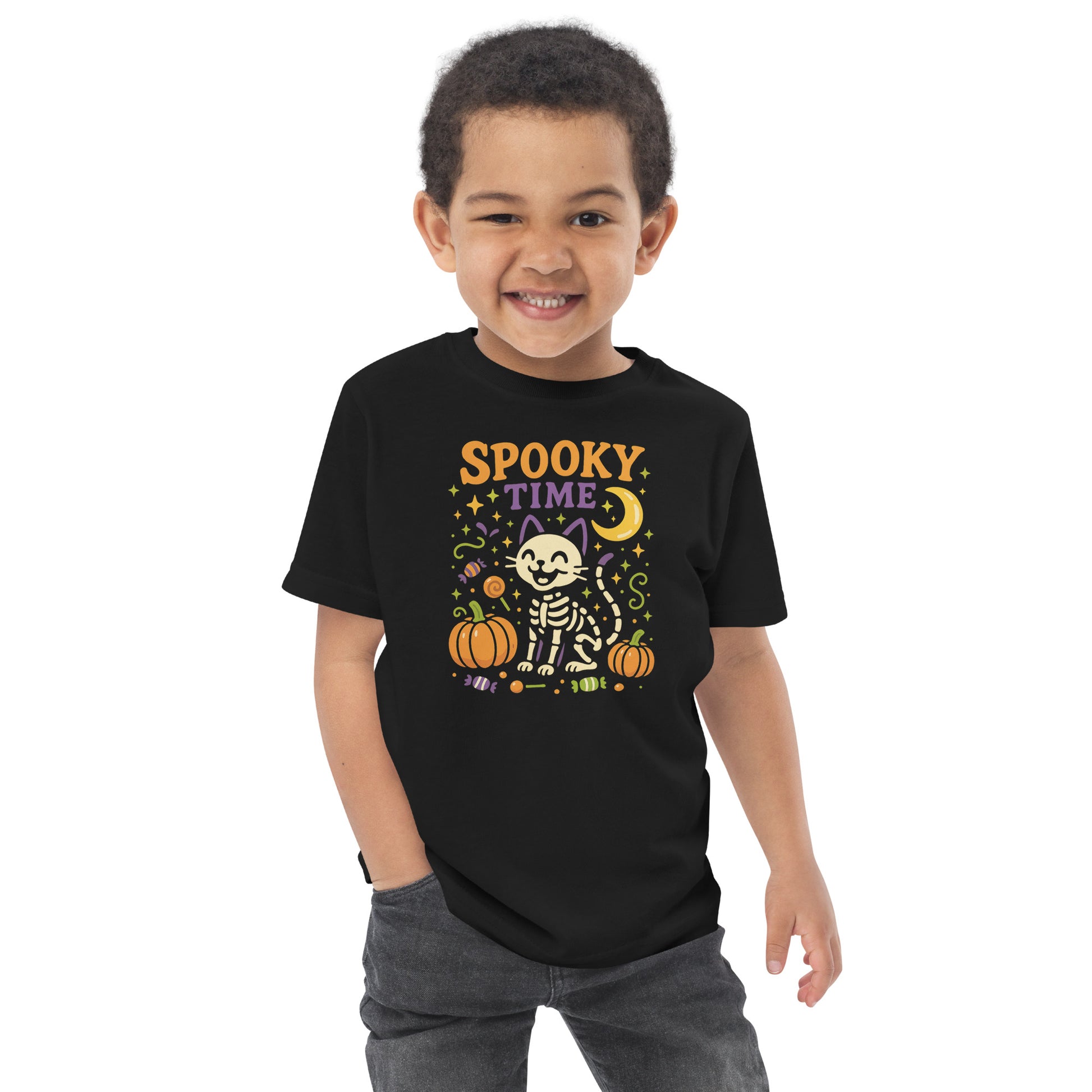 child wearing black shirt with the text "Spooky Time" and a skeleton cat next to pumpkins