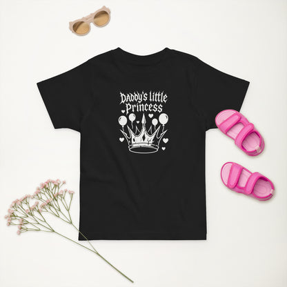 Black t-shirt with 'Daddy's little Princess' design, sunglasses, pink sandals, and dried flowers on a white background