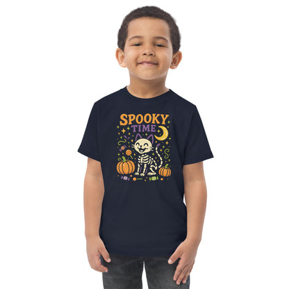 child wearing navy blueshirt with the text "Spooky Time" and a skeleton cat next to pumpkins