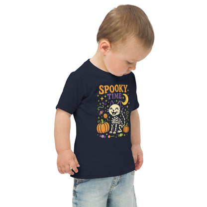child wearing navy blueshirt with the text "Spooky Time" and a skeleton cat next to pumpkins
