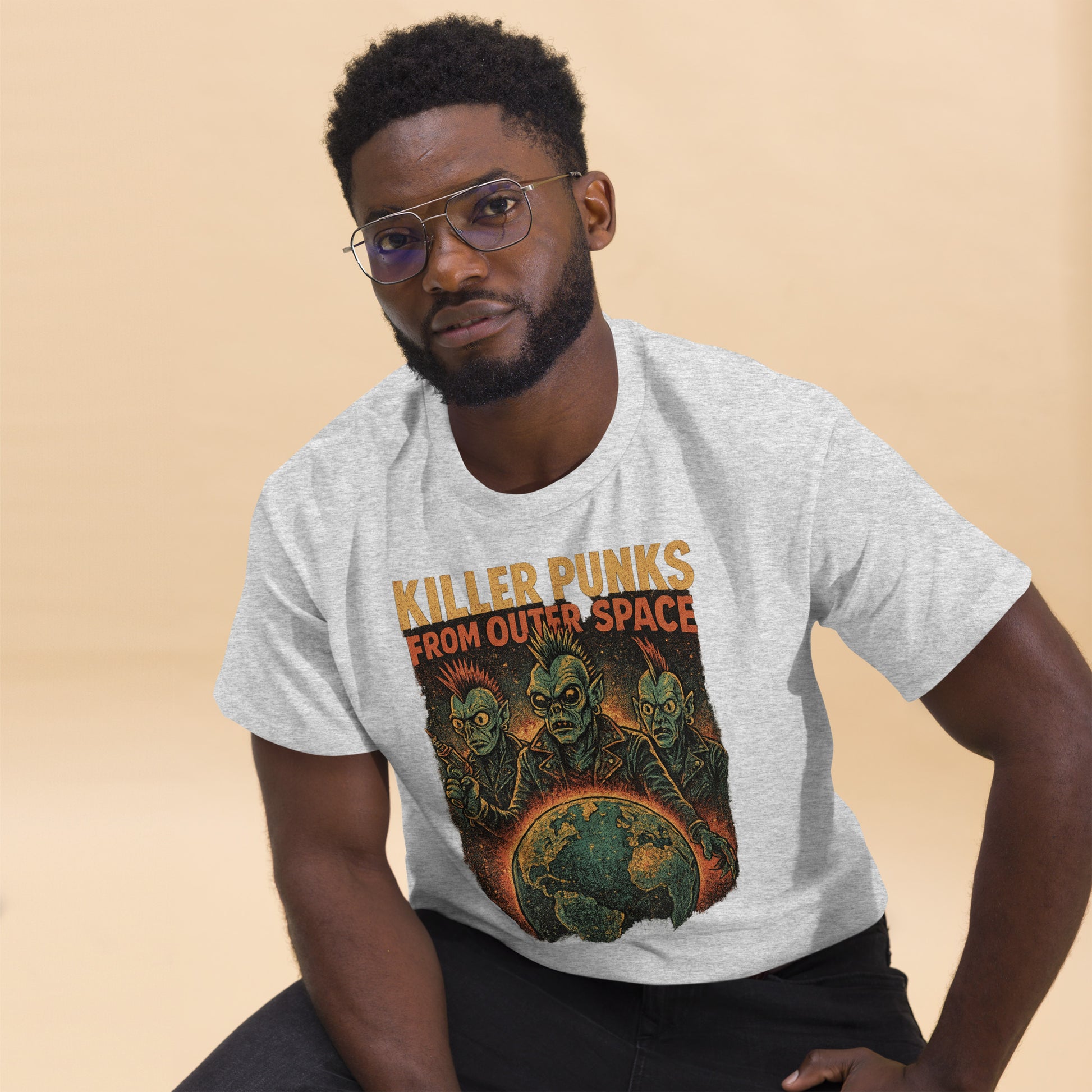Man wearing a t-shirt with 'Killer Punks from Outer Space' graphic design on a beige background