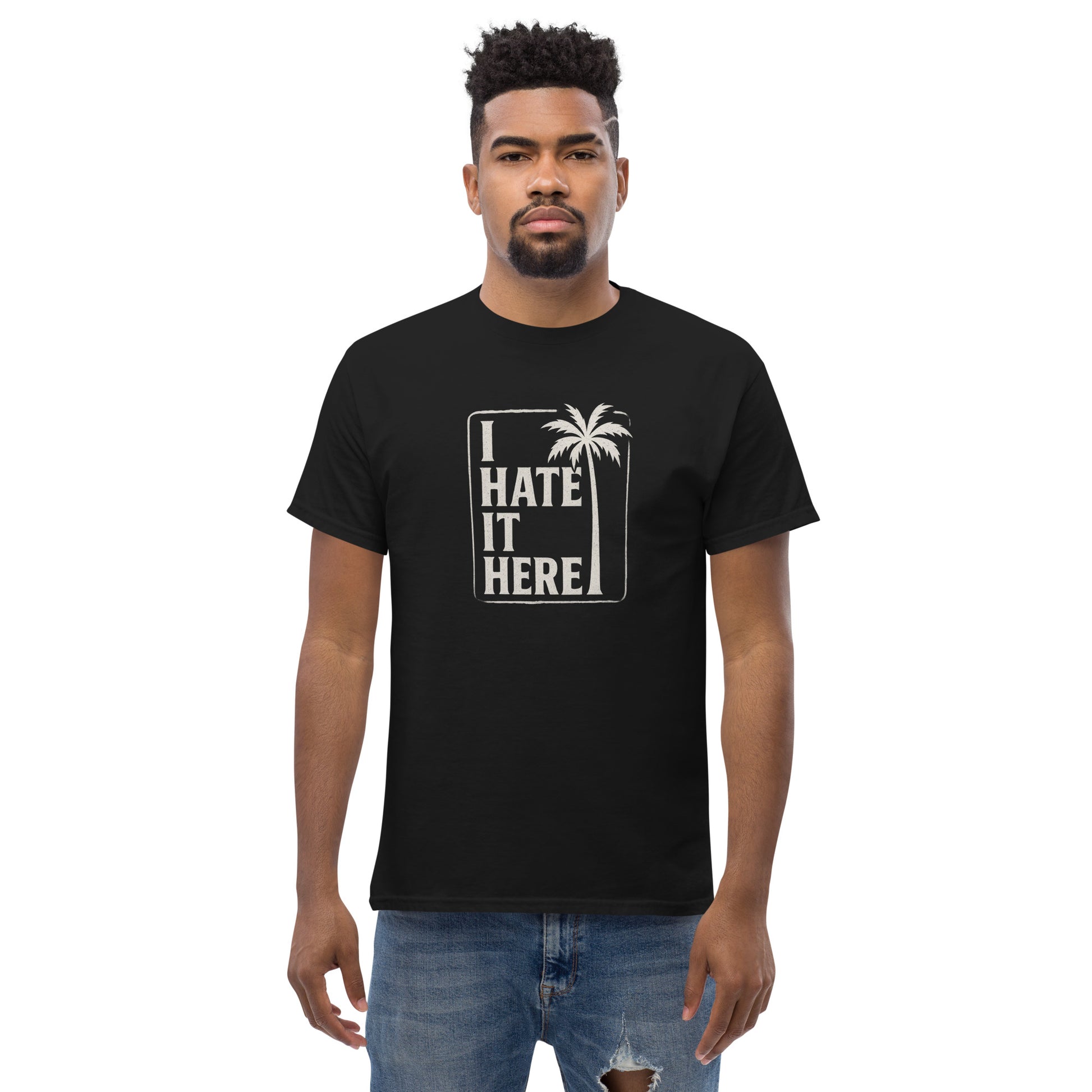 Person wearing a black t-shirt with 'I Hate It Here' text and palm tree graphic on a white background