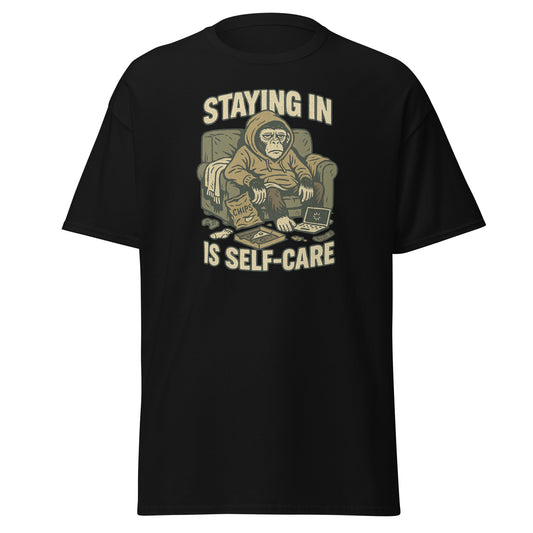 Black t-shirt with a graphic of a monkey in pajamas and text 'STAYING IN IS SELF-CARE' on a white background.