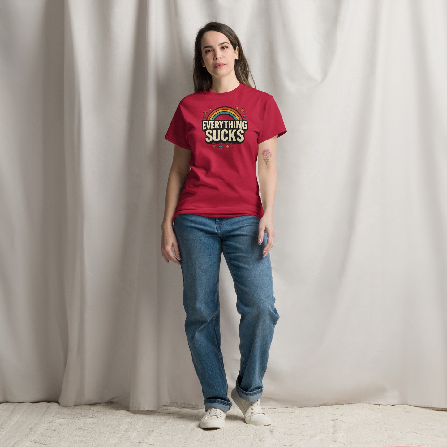 Person wearing a red t-shirt with text standing against a plain background