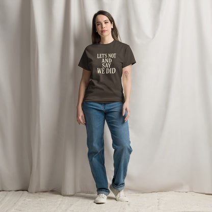 Person wearing a brown t-shirt with text and blue jeans standing against a plain background