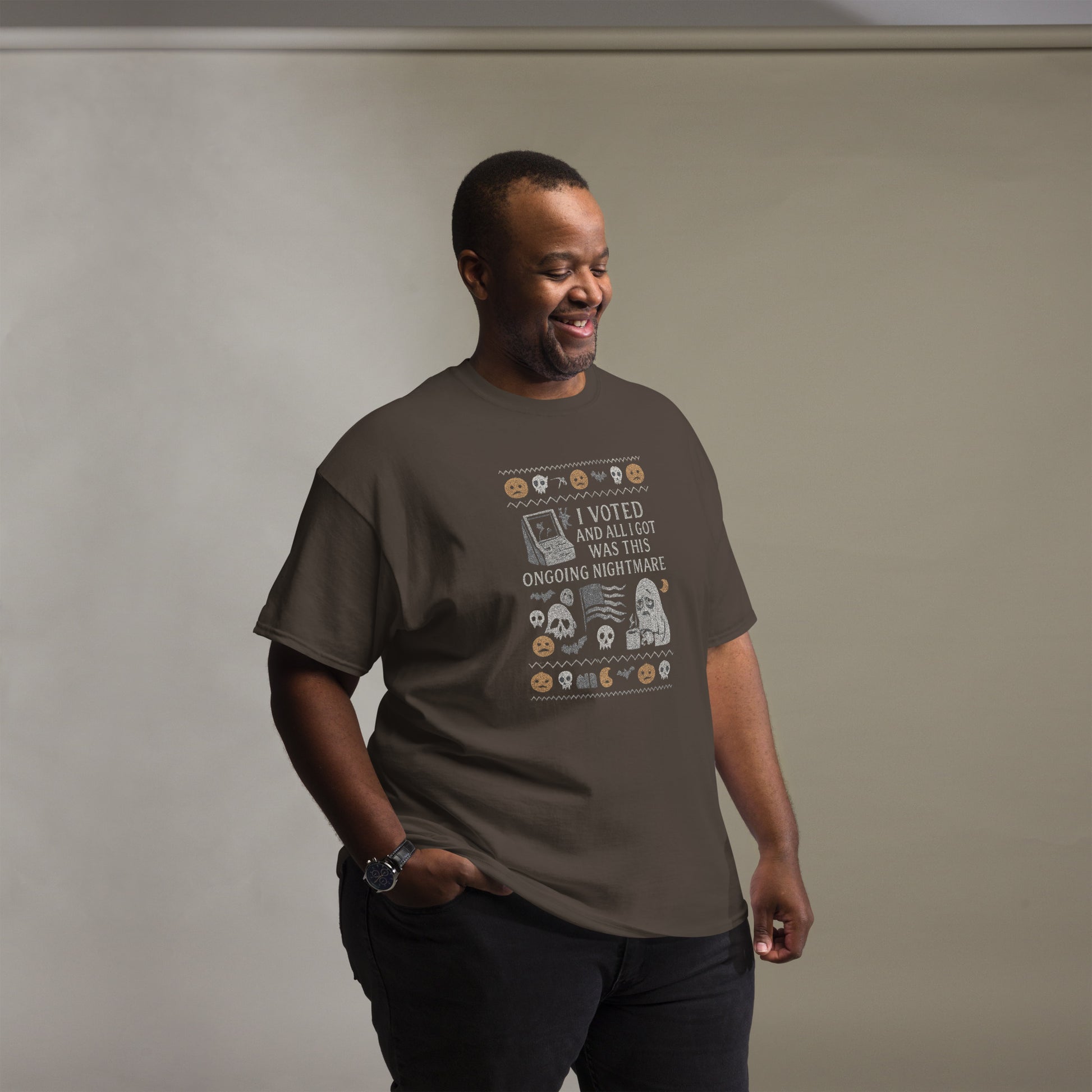 Man wearing a brown t-shirt with a graphic design on a plain background