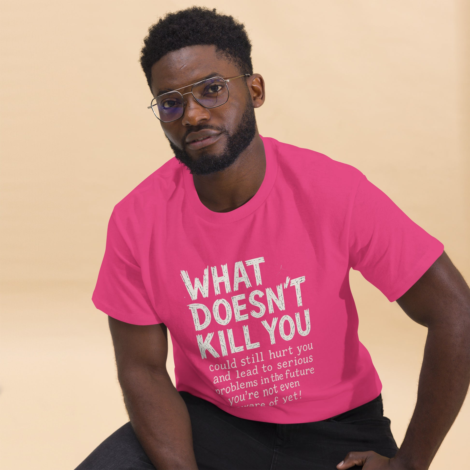 Man wearing a pink t-shirt with a motivational quote on a beige background
