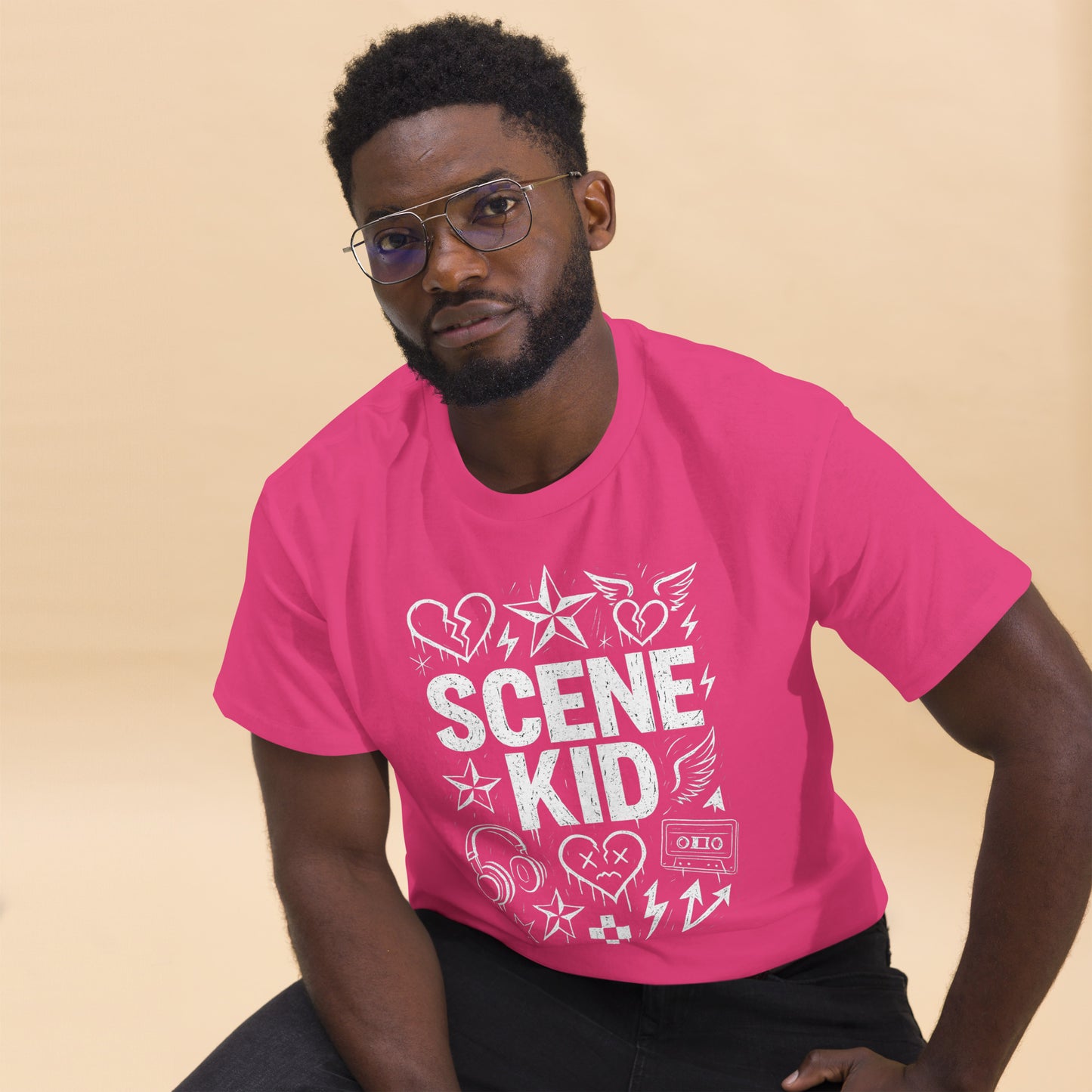 Man wearing a pink t-shirt with 'SCENE KID' design on a beige background