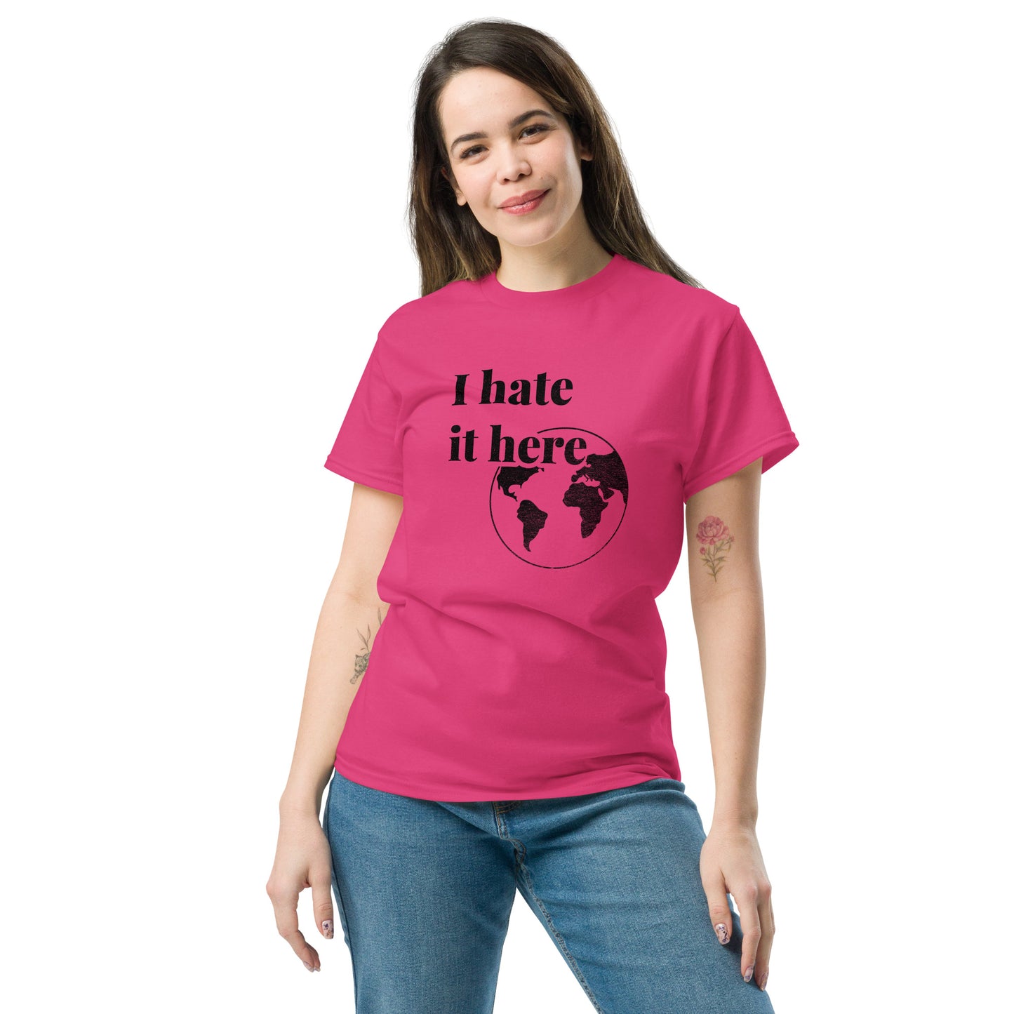 Person wearing a pink t-shirt with 'I hate it here' design on a white background