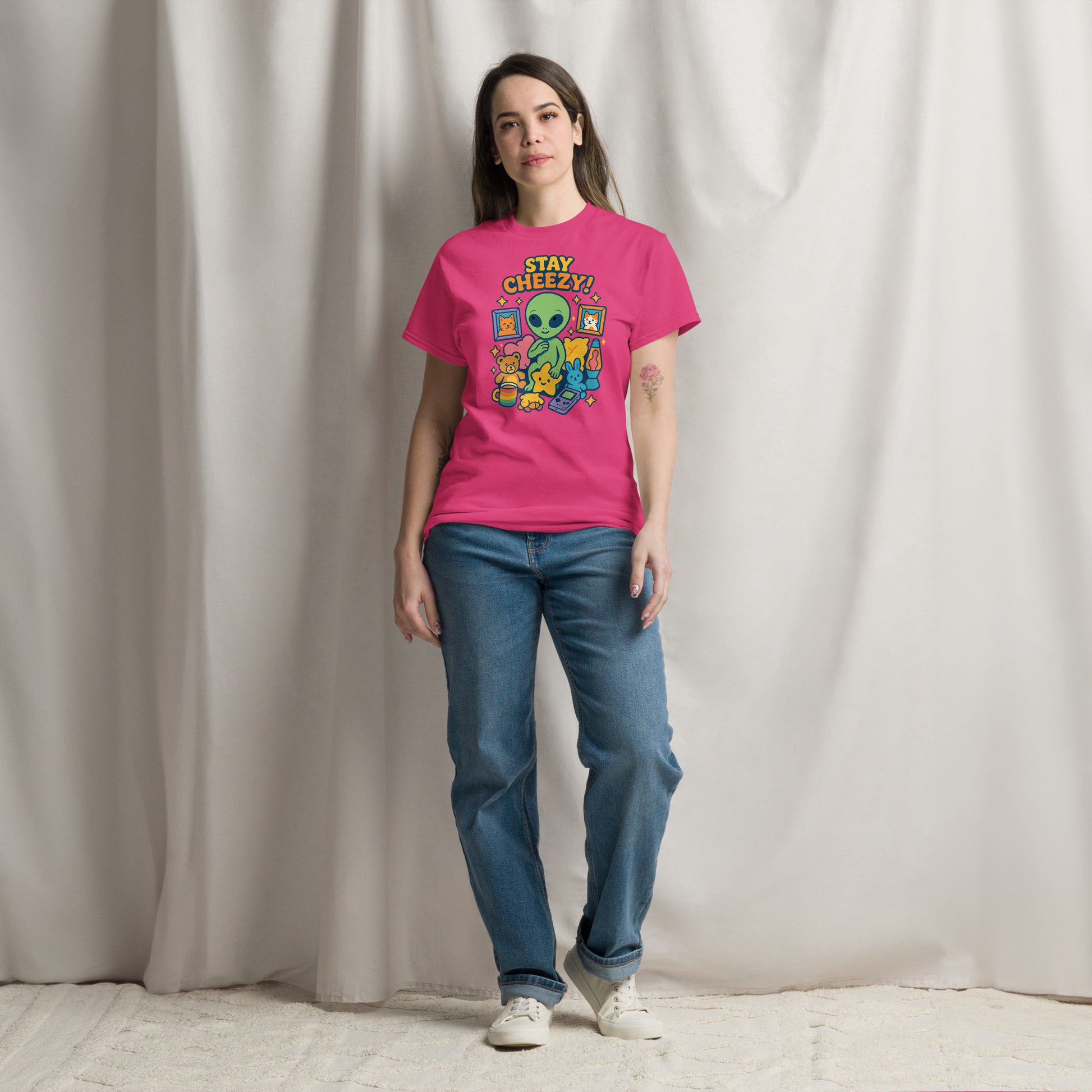 Person wearing a pink t-shirt with a graphic design and text, standing against a plain background