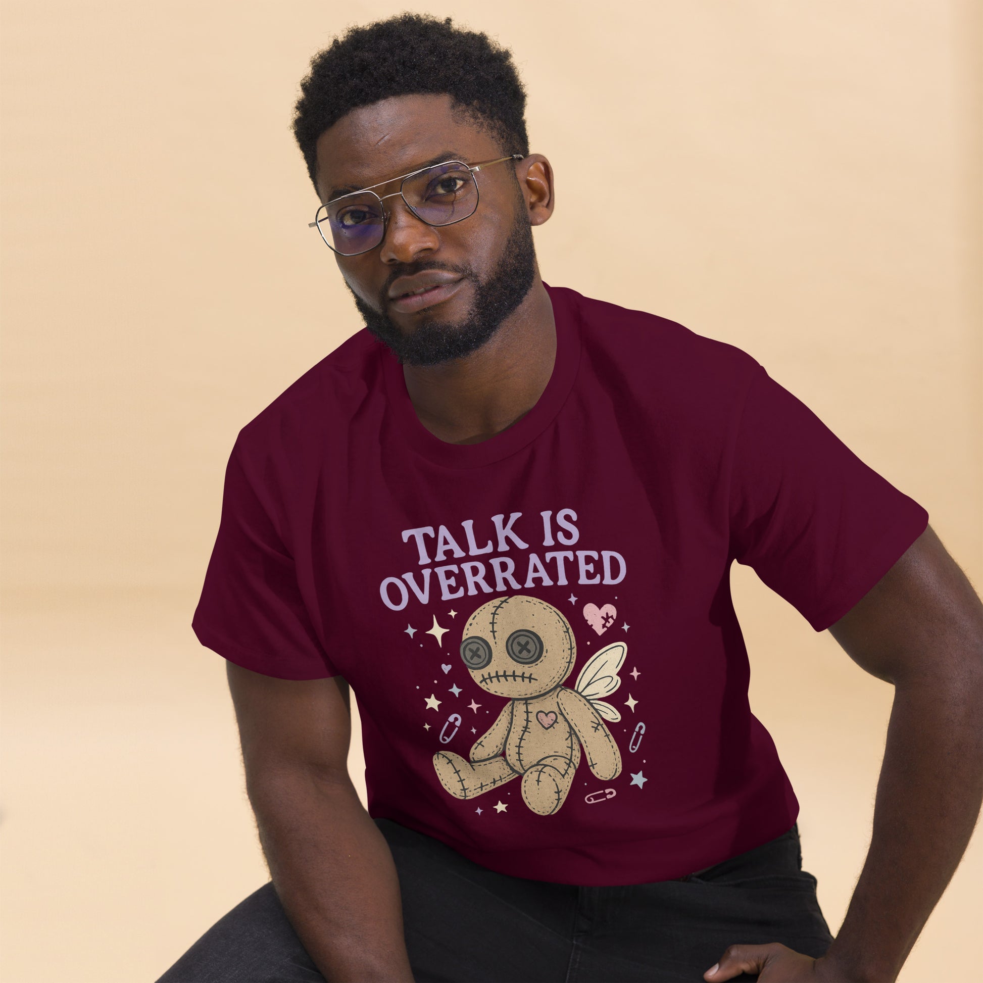 Man wearing a maroon t-shirt with a graphic design and text on a beige background