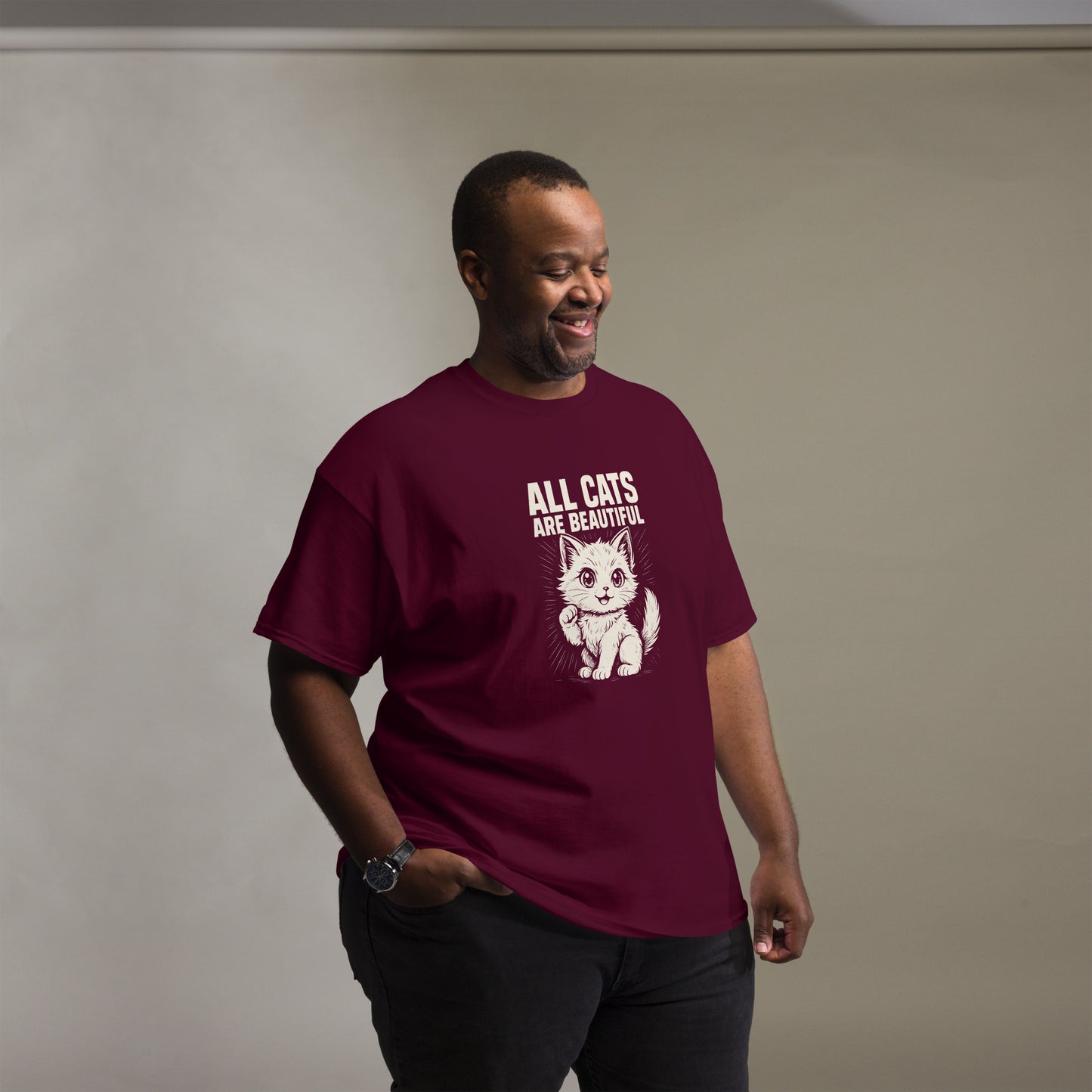 Man wearing a maroon t-shirt with a cat graphic and text against a plain background