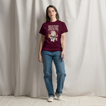 Person wearing a maroon t-shirt with a graphic design against a plain background
