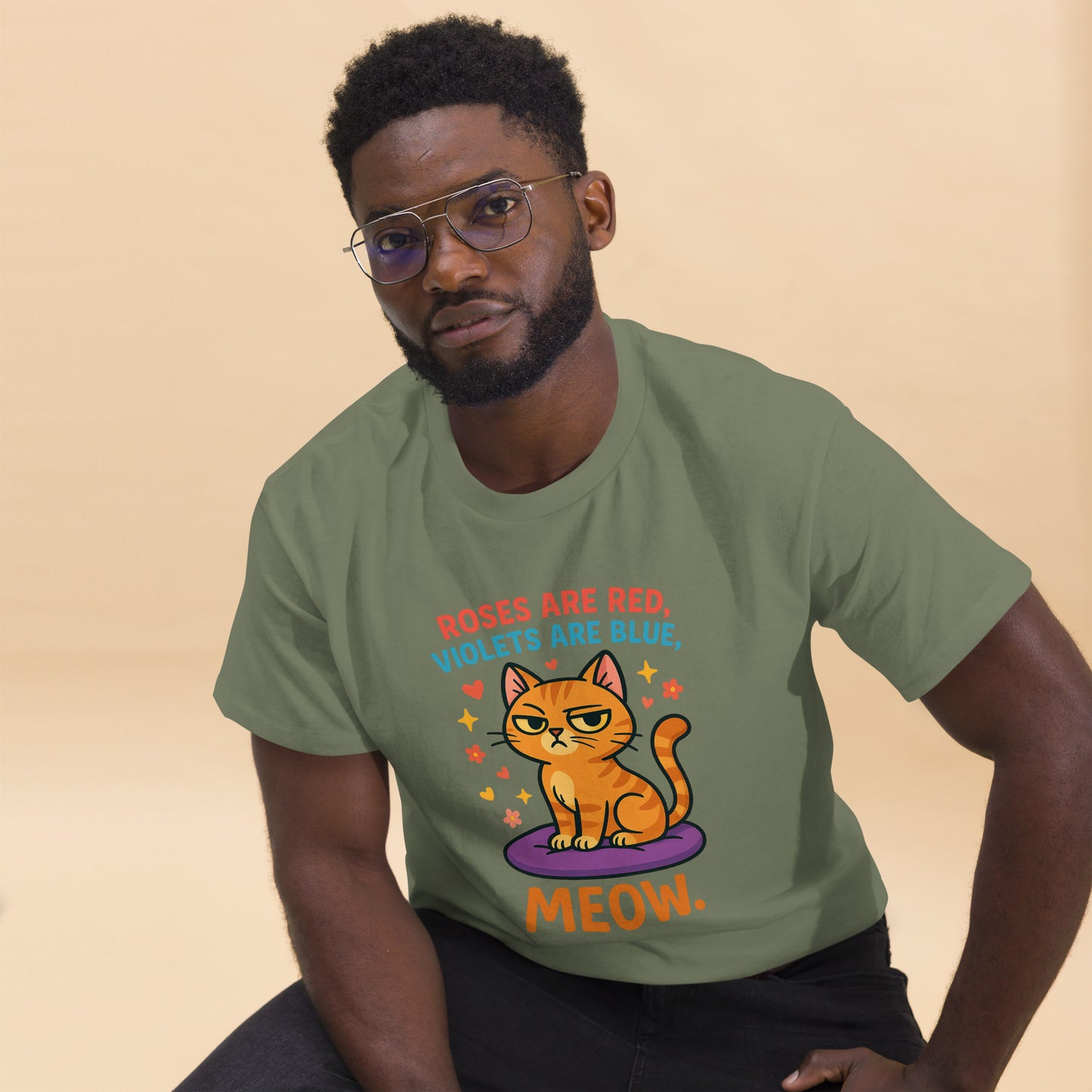 Man wearing a green t-shirt with a cat graphic and text on a beige background