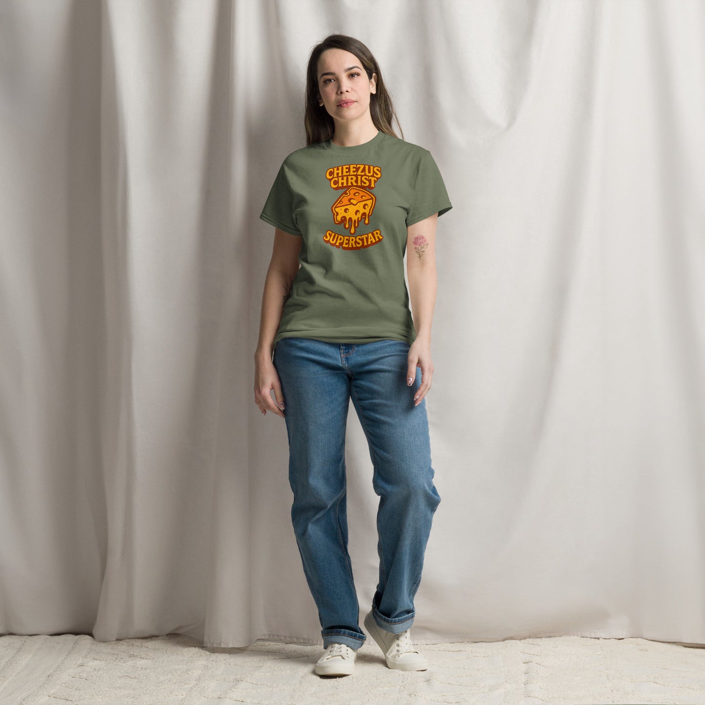 Person wearing a green t-shirt with a graphic design and text, standing against a plain background