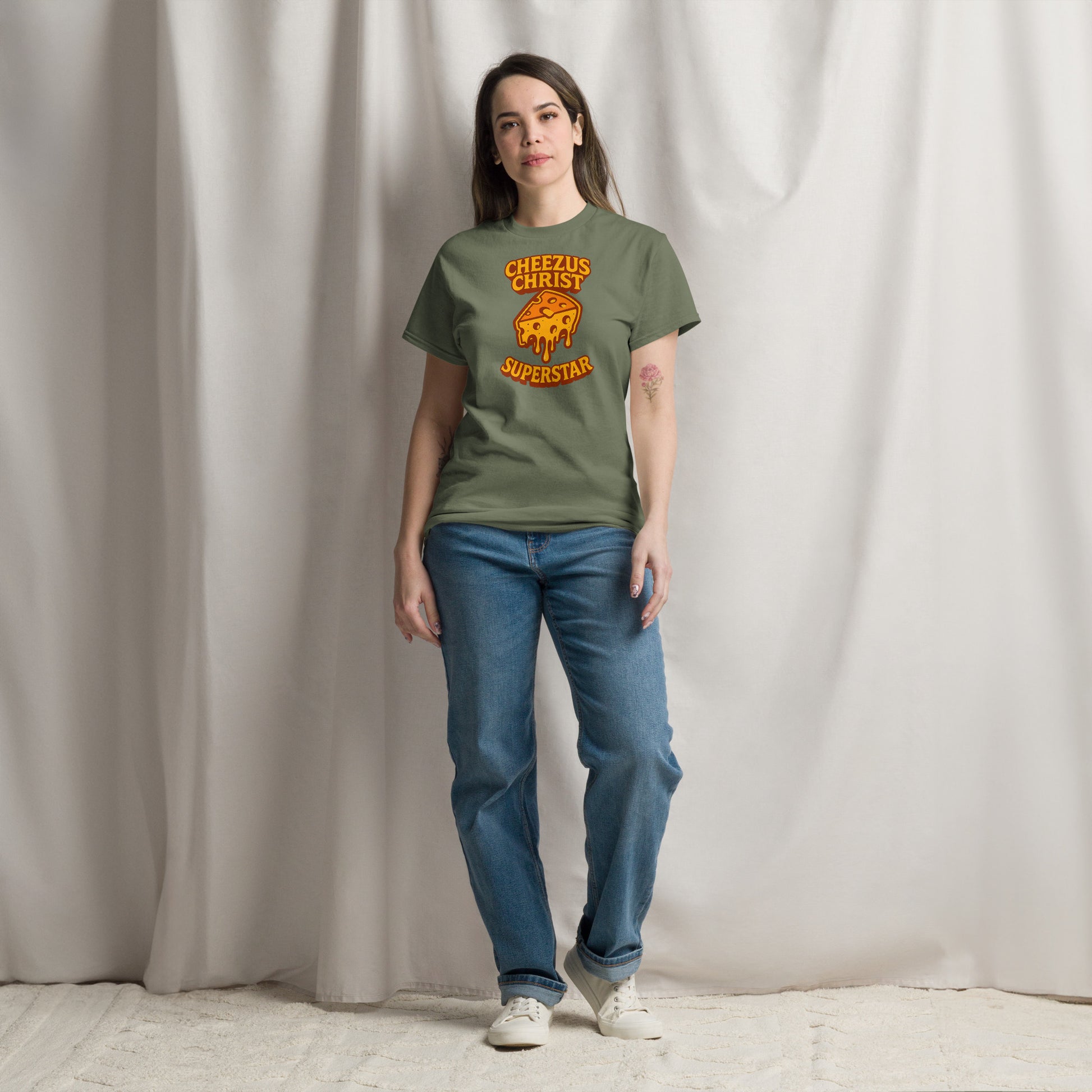 Person wearing a green t-shirt with a graphic design and text, standing against a plain background
