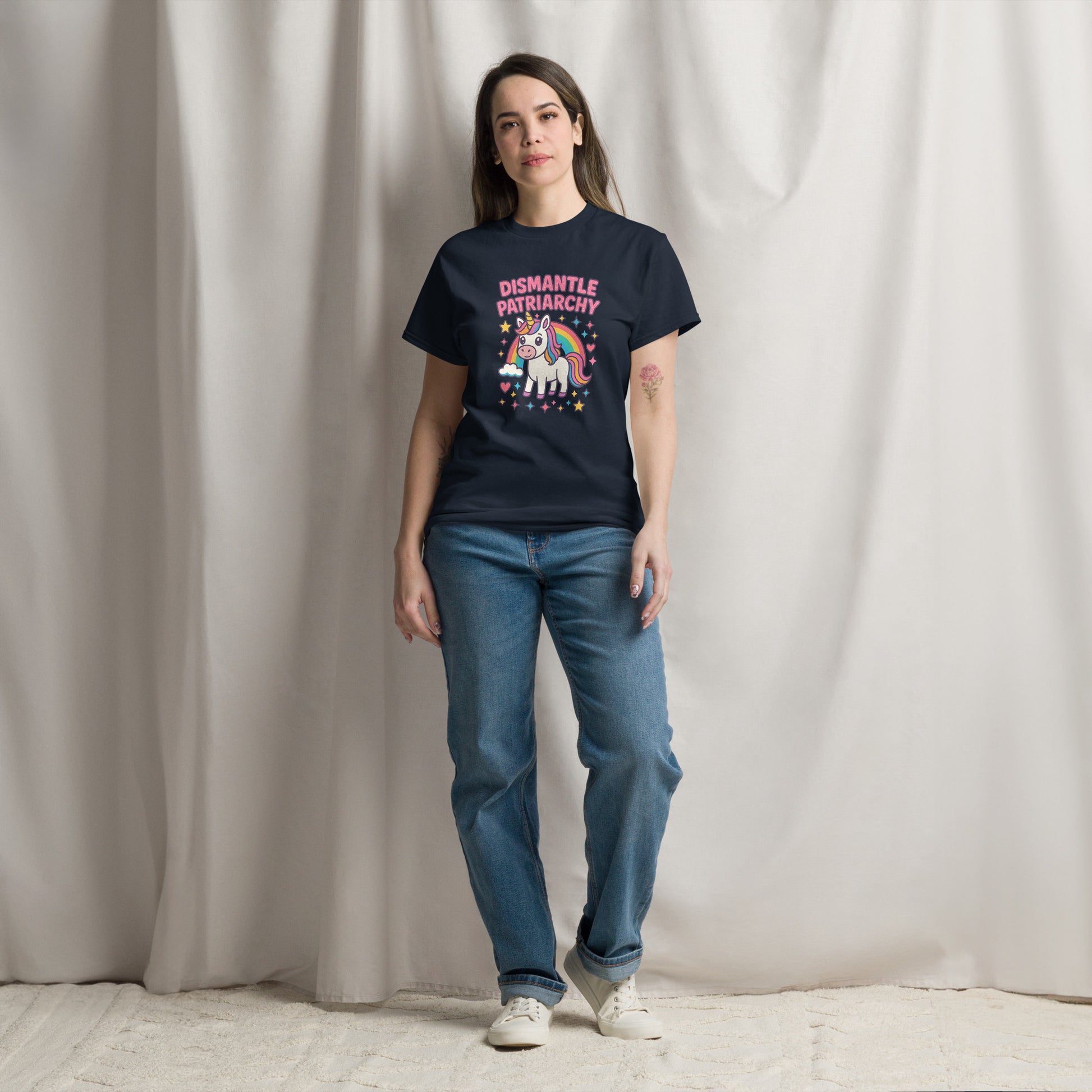 Person wearing a black t-shirt with a colorful graphic and text, standing against a plain background