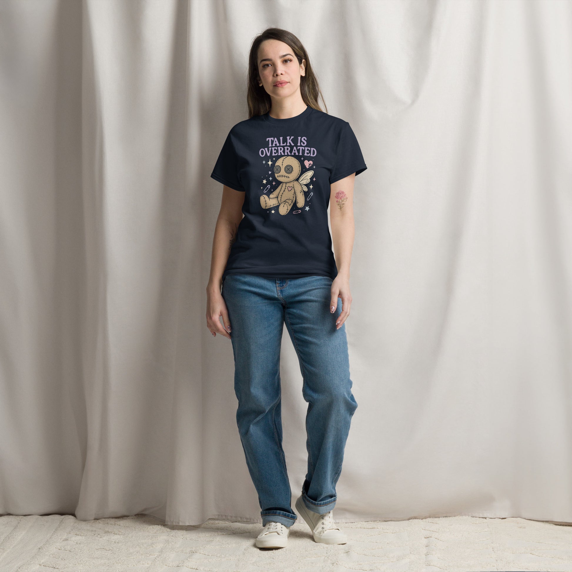 Person wearing a black t-shirt with a graphic design and text, standing against a plain background